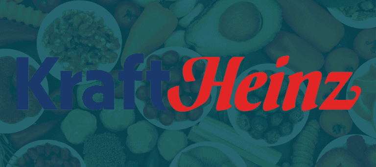 The Kraft Heinz logo with Kraft in blue and Heinz in red, overlaid on a background of various fruits and vegetables arranged in bowls.