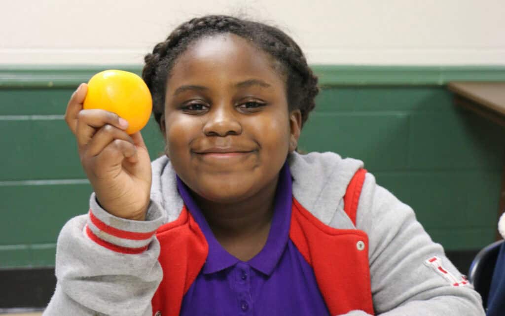 A child holding an orange