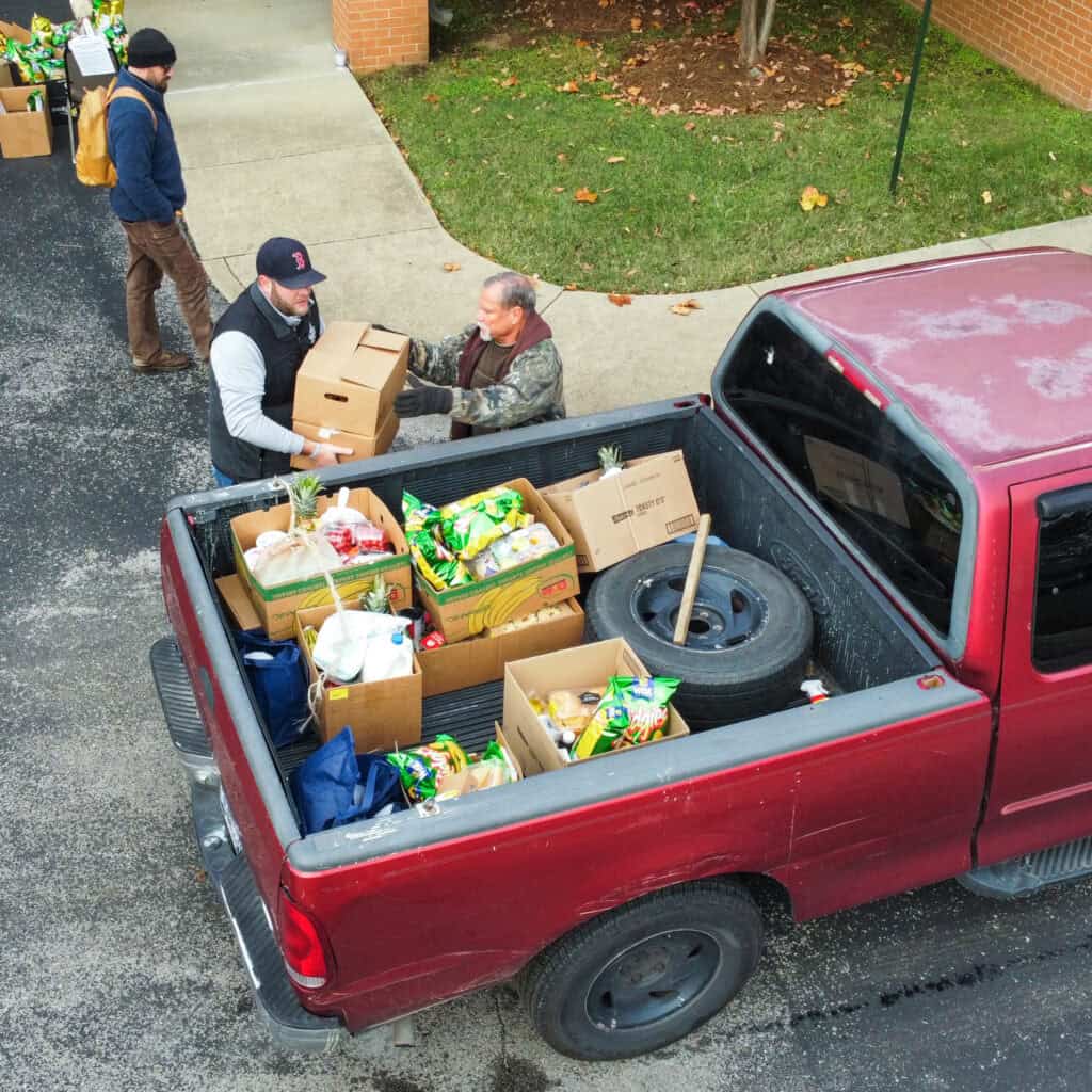 A volunteer loading food in a truck of someone facing hunger. To find meaningful volunteer opportunities like this, click the photo.