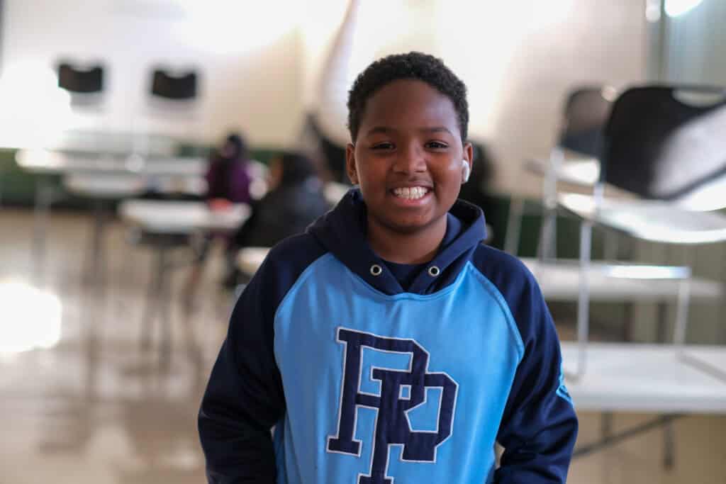 Brennan smiles inside a community center where he receives free summer meals through Second Harvest’s Hunger Free Summer program.