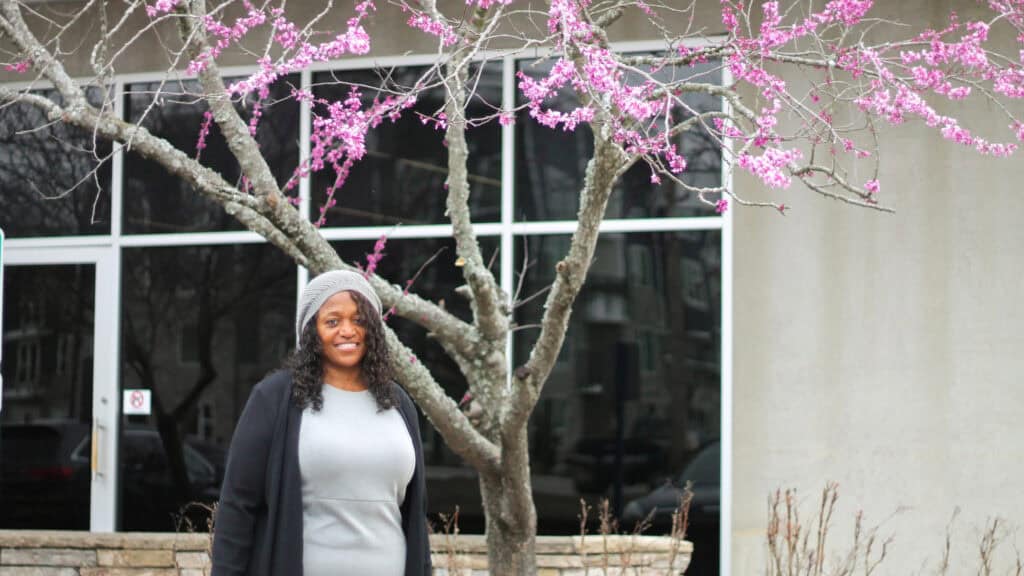 Honoring Juneteenth: Leader of Connectus Health stands outside in front of blooming tree, highlighting community partnerships and equity in food access.