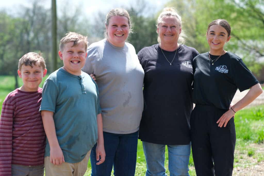 Family from Old Stone Creamery smiling together on the farm, highlighting their commitment to Dairy and Child Nutrition through local milk production