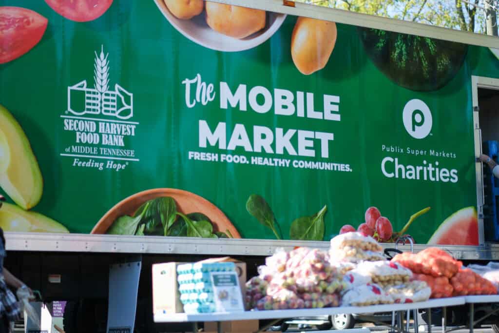 A Second Harvest Food Bank of Middle Tennessee Mobile Market truck, sponsored by Publix Super Markets Charities, delivering fresh produce and groceries to the community. This scene highlights why truck drivers are essential in fighting hunger—transporting fresh food, stocking shelves, and connecting neighbors with healthy meals