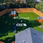 A fenced backyard with green artificial grass, two hot tubs, and people relaxing. Overlayed text reads Framework x CREW. Trees surround the yard and part of a house roof is visible in the foreground.