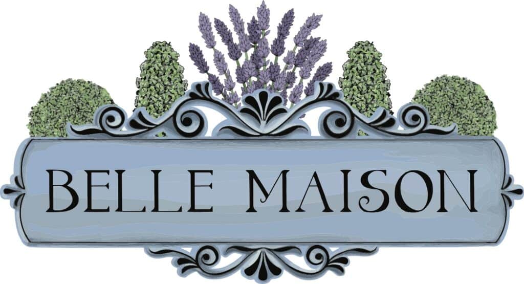 A decorative blue sign with the text BELLE MAISON in bold letters, adorned with ornate scrollwork, lavender flowers, and green shrubs at the top.