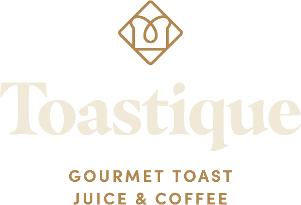 Logo for Toastique, a gourmet toast, juice, and coffee shop. The logo features a stylized icon above the brand name Toastique in large letters, with Gourmet Toast Juice & Coffee below.