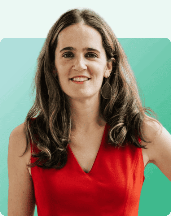 Woman with long brown hair wearing a sleeveless red dress stands smiling in front of a teal gradient background with rounded corners.