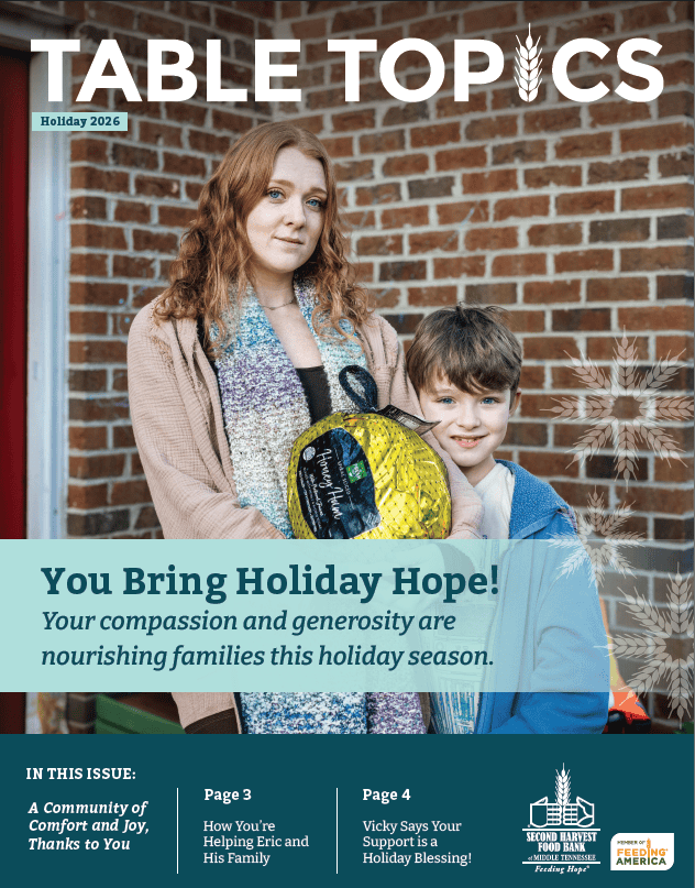 A woman and young boy stand in front of a brick wall holding a wrapped holiday ham for a Second Harvest Food Bank newsletter cover titled Table Topics.